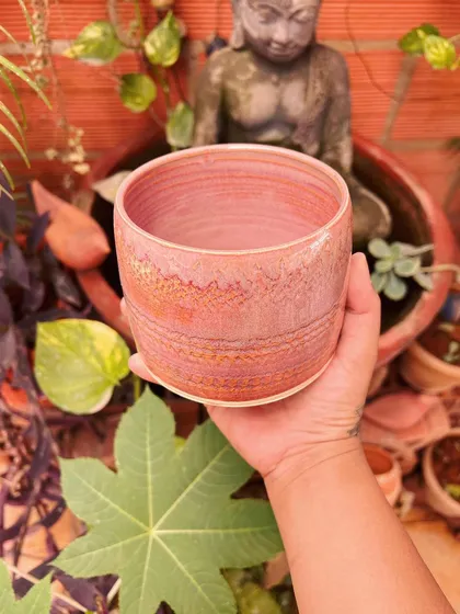 A close-up of a pink textured planter I made. The Buddha statue in the background brings a sense of peace to my workspace.