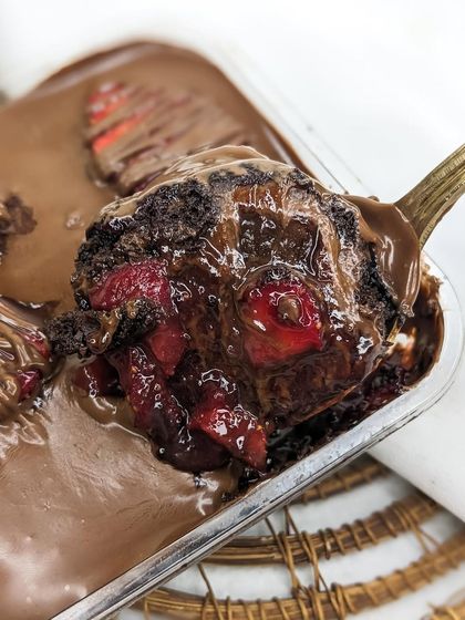A close-up of a spoonful of our Nutella Strawberry cake tub. The glistening homemade strawberry compote and rich chocolate sponge are clearly visible, showcasing the quality of our ingredients.