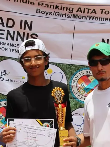 A young champion with his trophy and coach.