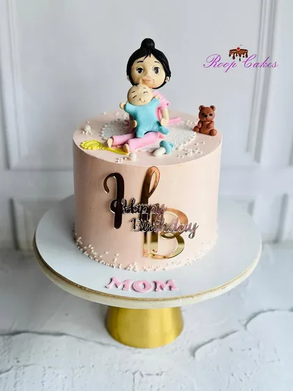 A beautiful handcrafted edible figurine of a mom and her baby, made for a special first birthday celebration.