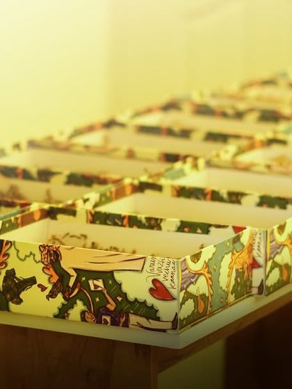 A line of the custom doodle art boxes, ready to be filled. This shot gives a sense of the large-scale production for events.