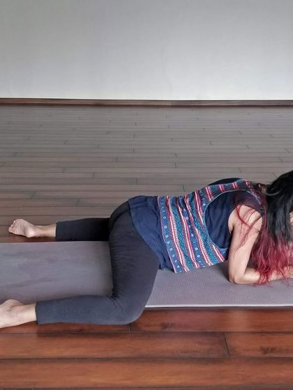 A student in Mandukasana (Frog Pose), a deep hip opener that stretches the inner thighs and groin. This pose invites us to find grace and stillness in discomfort.