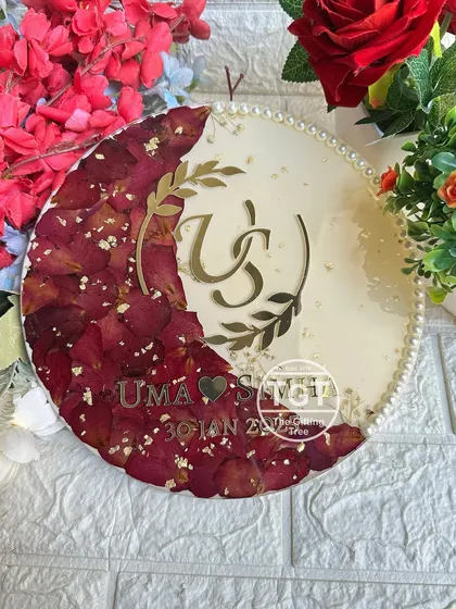 A clear, top-down shot of the plaque, showing the intricate details of the preserved petals and gold flakes.