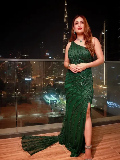 A full-length view of Neha Malik's stunning green gown. The thigh-high slit and one-shoulder design add a modern and alluring touch to this classic evening wear silhouette.