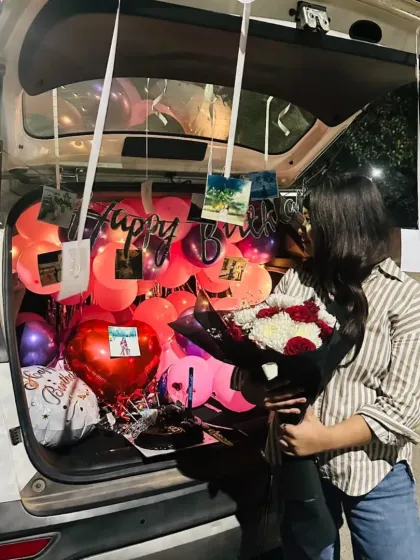 A candid moment of the recipient admiring her personalized car boot surprise decoration.