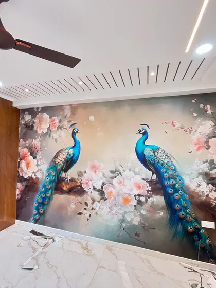 This stunning peacock-themed wallpaper has been installed in a client's room. The vibrant colors and intricate details of the birds and flowers create a majestic and artistic feature wall, enhanced by the slatted ceiling design.