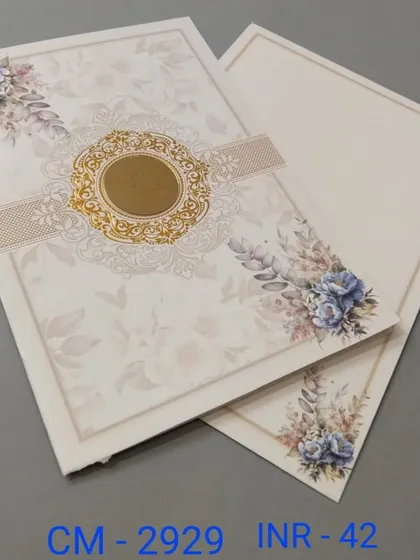This card features a beautiful blue floral print on a cream background. The design is tied together with a central band and a gold emblem.