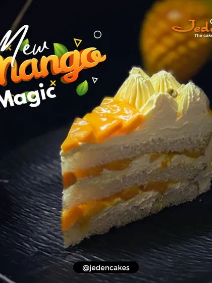A slice of our New Mango Magic pastry. This dessert features layers of light sponge, creamy filling, and fresh mango pieces, capturing the authentic taste of the season.