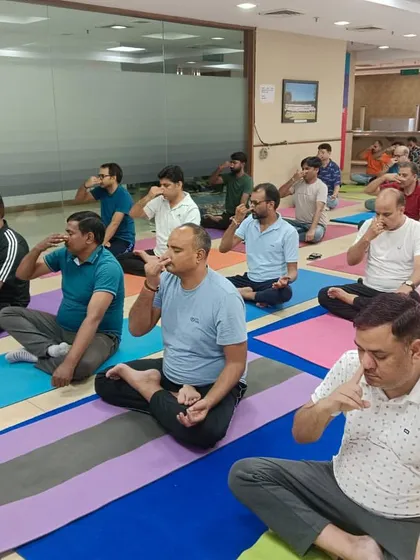 Participants in a corporate session practice Nadi Shodhana (Alternate Nostril Breathing). This is an excellent pranayama technique for balancing energy and calming the mind, perfect for a midday reset.