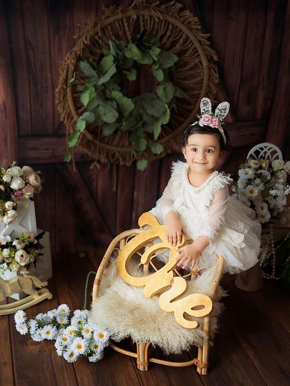 Celebrating one year with a rustic, barn-door backdrop and a cute bunny headband. This setup is perfect for a classic and charming first birthday photoshoot.
