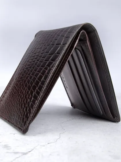 A standing shot of a dark brown crocodile-textured wallet.
