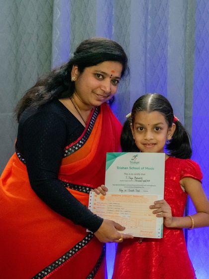 A happy student receives her certificate for passing her graded music exam.