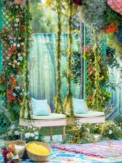 Another angle of the whimsical floral swing, showing the colorful patterned rug and baskets of flower petals for the ceremony.