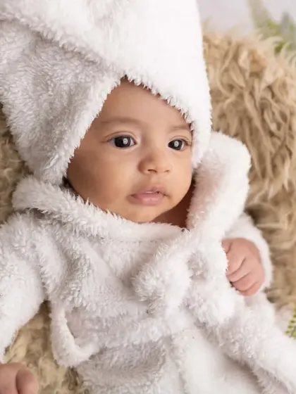 After a relaxing spa day, perhaps? This playful setup with a tiny bathrobe and towel wrap always brings out the smiles. It's a fun and creative way to capture your baby's personality during a sitter session.
