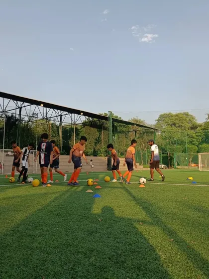 A wide view of a training session, with multiple players working on their individual ball skills. Repetition is key to mastery.