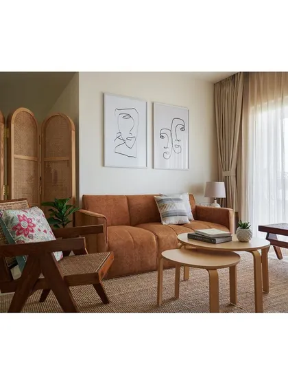 We designed this serene living room with bespoke furniture to create a cohesive and calming atmosphere. The space features our custom sofa, a handcrafted wooden armchair with cane detailing, and nesting coffee tables, all unified by a palette of warm, natural materials.