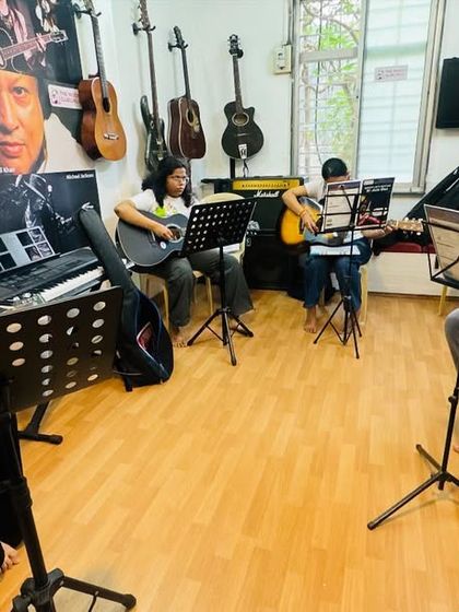 A typical group guitar session at the Gurukul. You can see students at different stages of learning, all focused on their sheet music, creating a collective learning environment where everyone progresses together.