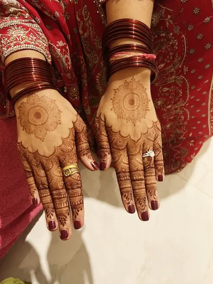 The stain on the back of the hands from a Karwachauth design. The mandala pattern has developed into a beautiful, deep color.