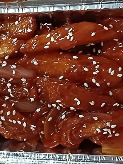 A close-up of my Chilli Potato, tossed in a sweet and spicy sauce and sprinkled with sesame seeds.