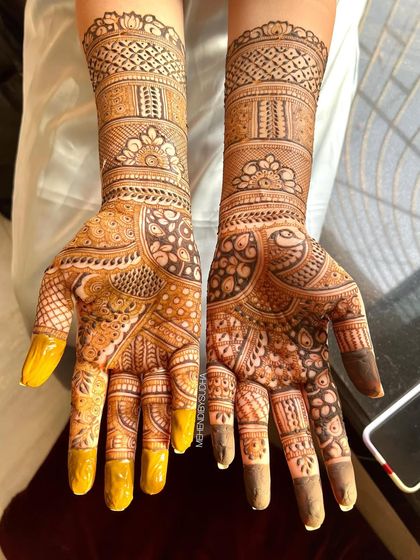 A beautiful bridal design with a mix of traditional Indian patterns, including paisleys and checks, showing a lovely two-tone stain.