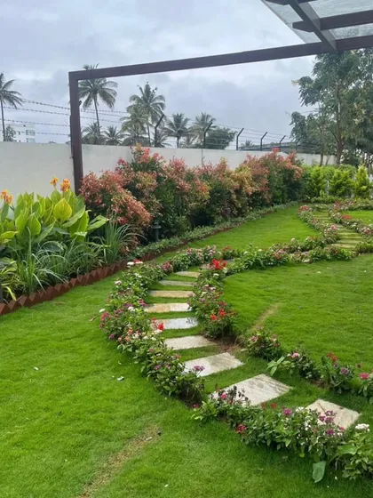 For this project, we created a classic garden feel with a lush natural grass lawn bordered by vibrant flowering plants. A winding stone pathway invites a gentle stroll through the space, connecting different areas of the garden seamlessly.