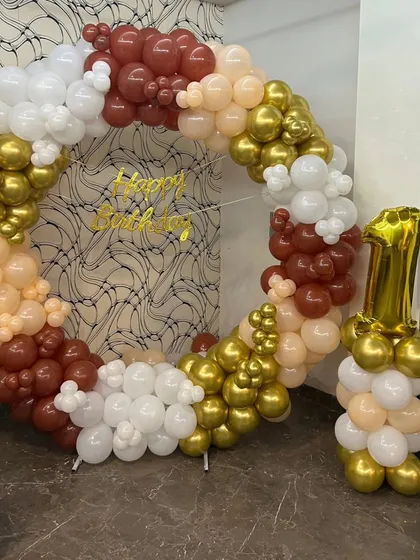 A clear, straight-on view of the elegant first birthday balloon ring. This type of organic garland with a mix of matte and chrome balloons is a popular choice for modern and stylish celebrations at home.