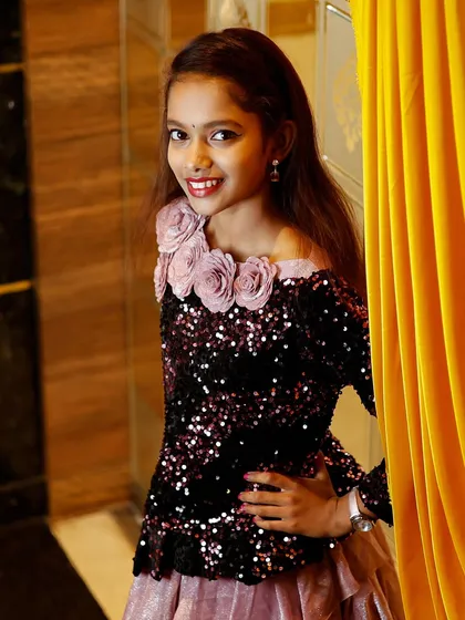 A young girl dressed up for a party, posing confidently for the camera. I enjoy capturing the personalities of children at events.