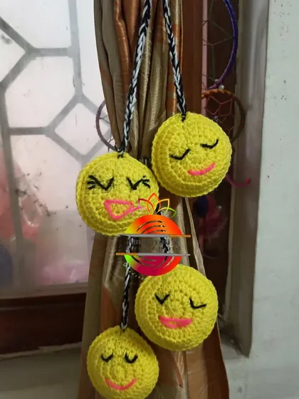 Spread some cheer with these smiley face curtain tie-backs. Each yellow circle is crocheted with a cute, winking expression for a fun and happy vibe.