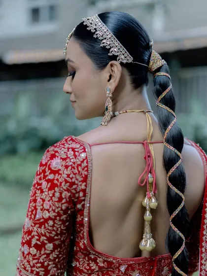 The back view is just as important. The sleek, modern braid is the perfect complement to the traditional lehenga and the classic makeup look.