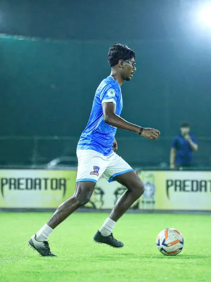 A young player dribbling the ball with speed and control.