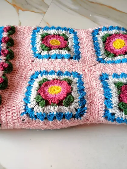 The blanket folded neatly, showing the pattern and the texture of the stitches. A project like this is a true labor of love.