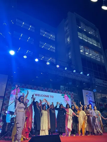 A final group wave with all the performers and organizers on the carnival stage.