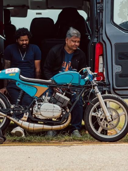 A custom cafe racer, a beautiful blend of vintage style and modern performance, sits ready for its run.