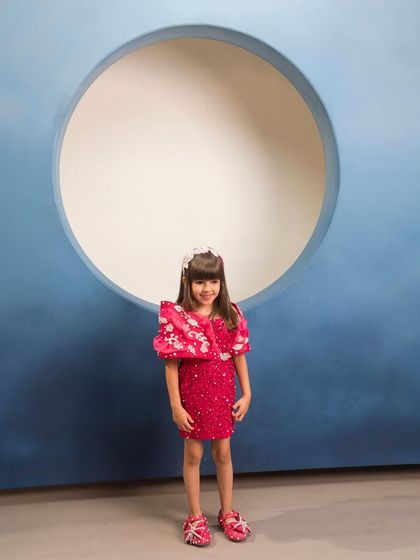 Our magenta short dress is one of our most booked pieces, featuring a structured shoulder detail.