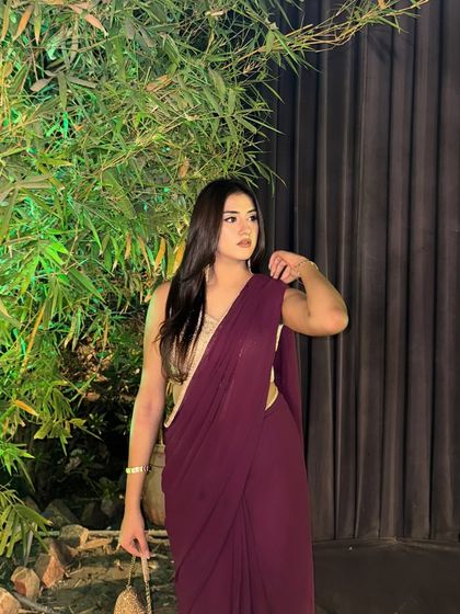 Posing elegantly in the purple saree against a backdrop of green bamboo, showcasing the simple yet stunning drape.