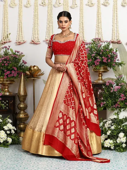 The rich red Banarasi dupatta, with its intricate weave, is a statement piece in itself, adding a layer of luxury to the entire bridal ensemble.
