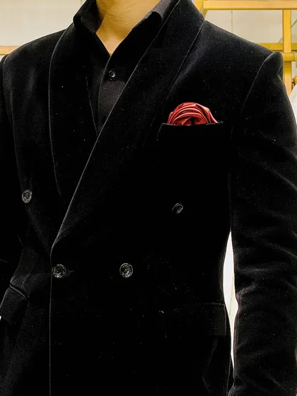You can never go wrong with a classic. This is a close-up of our double-breasted tuxedo in rich black velvet, a staple for any formal event that guarantees a sharp, sophisticated look.