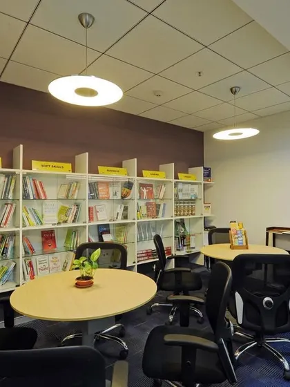 A multi-purpose space that functions as both a lounge and a library, with bookshelves and comfortable seating for reading or informal meetings.