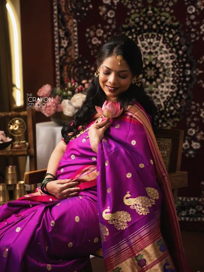 Holding a lotus flower, a symbol of purity and rebirth, she sits in quiet contemplation. This is a beautiful, symbolic portrait from a traditional maternity session.