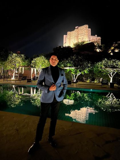A nighttime shot by the pool with Alila Fort in the background. The dramatic lighting creates a cool, sophisticated mood.