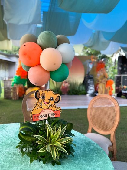 Another view of the themed table centerpiece, showing the arrangement of balloons and the personalized "Kiyansh Turns 1" sign.
