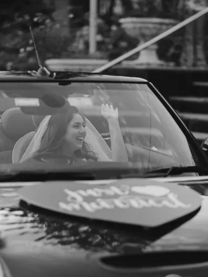 "Just Married!" The couple drives off in a convertible, waving happily. This black and white shot feels like a scene from a classic romantic movie, a perfect end to their church wedding.