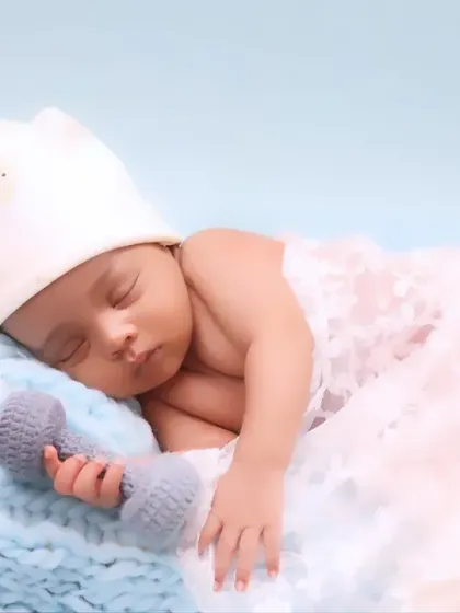 Our newborn sessions are designed to be calm and peaceful. Here, a sleeping baby is captured in a miniature bed, swaddled gently to highlight their delicate features and serene expression.
