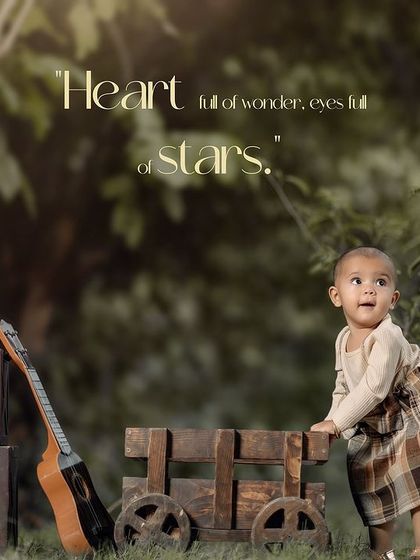 A beautiful outdoor first birthday portrait with a rustic wooden cart and guitar, capturing a moment of quiet curiosity.