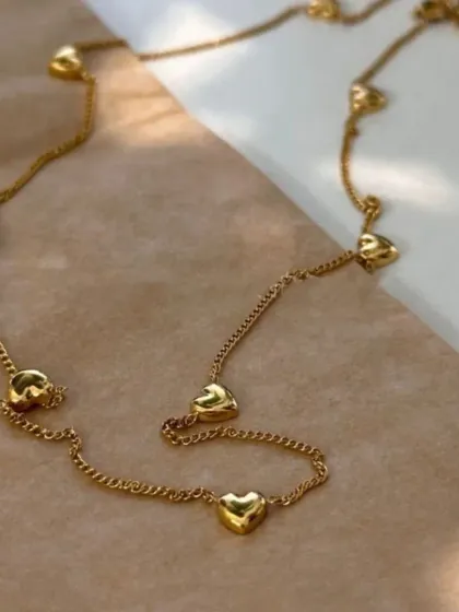 A product shot of the puffy heart station necklace, laid out to show the full length and design. Made from guaranteed stainless steel.