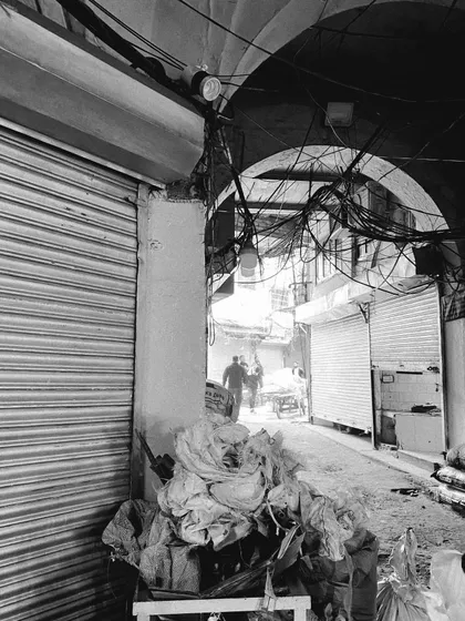 A view through an archway into a narrow, bustling lane, capturing the depth and activity of the city.