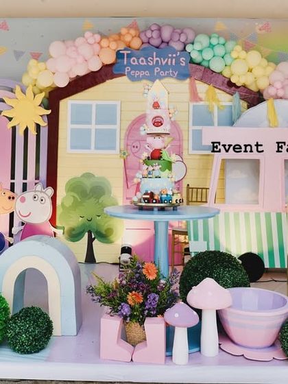 A closer look at the Peppa Pig dessert table, featuring the cake set in front of Peppa's house, surrounded by mushroom props and other fun details.
