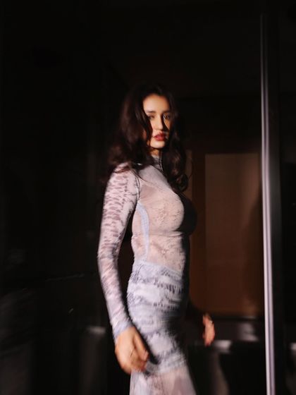 This moody, atmospheric shoot features Disha Patani in a sheer printed dress by Deme Love for the 'Kanguva' promotions. The styling here was about creating an alluring and mysterious vibe, playing with light and shadow.