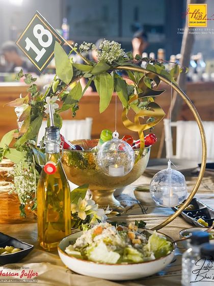 Attention to detail is key to our decor. This centerpiece combines natural greenery with delicate, candle-lit glass baubles and Arabic calligraphy, adding a personalized and elegant touch to the guest tables.