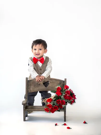 The most charming little valentine you've ever seen. Dressed in a vest and bow tie, this little man is ready to steal hearts with his bouquet of roses.
